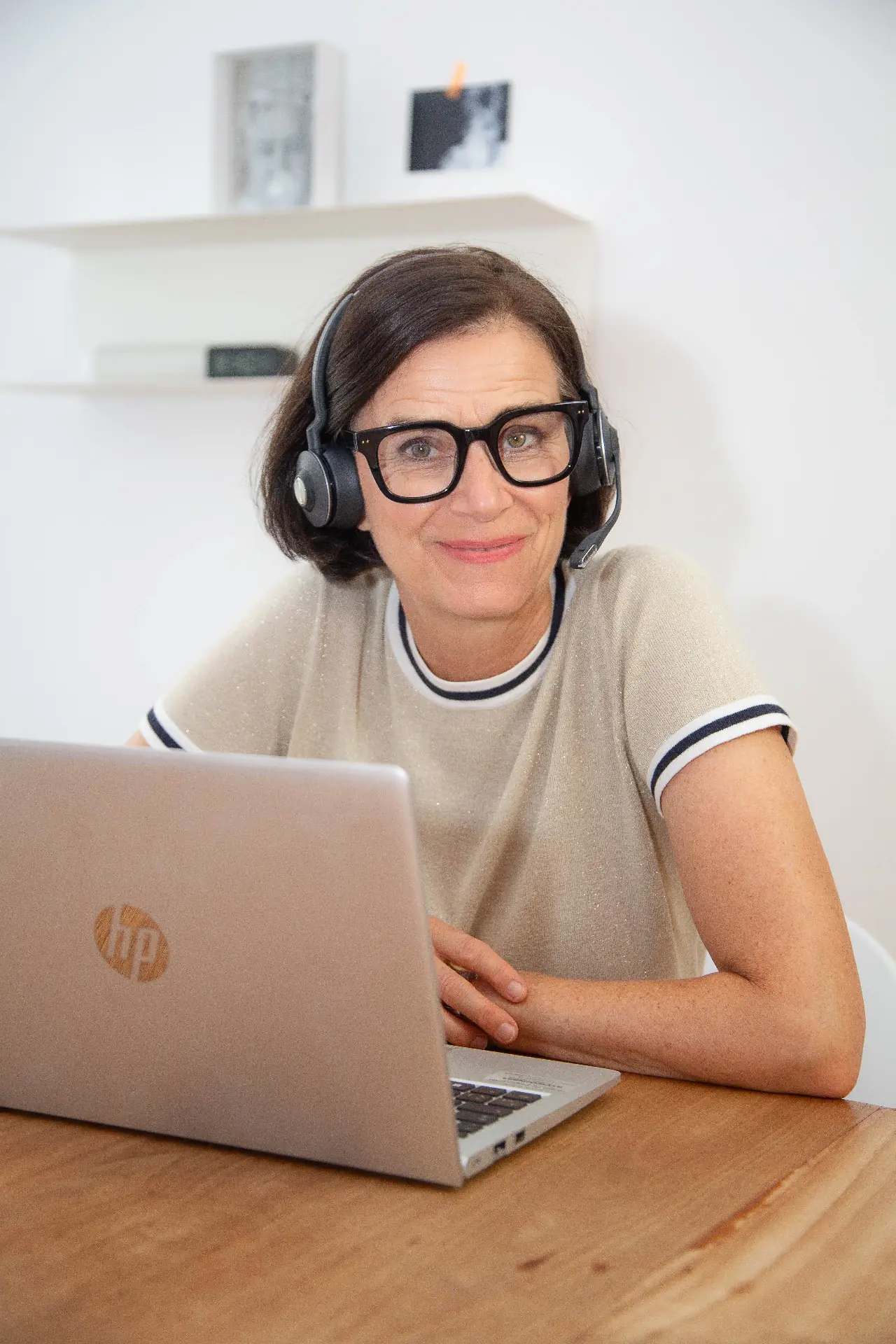 Sabine Bertassi beim Podcasten mit Headset am Laptop